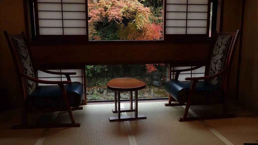 A candle-lit ryokan interior opening onto a moss garden at dusk